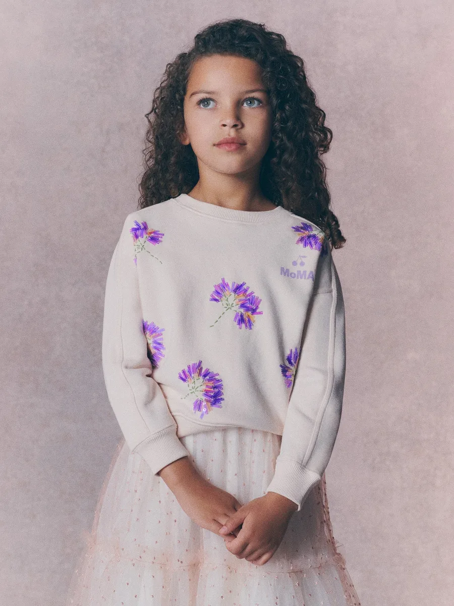 Mädchen im Sweatshirt von Bonpoint x MoMA mit Blumen und Perlen