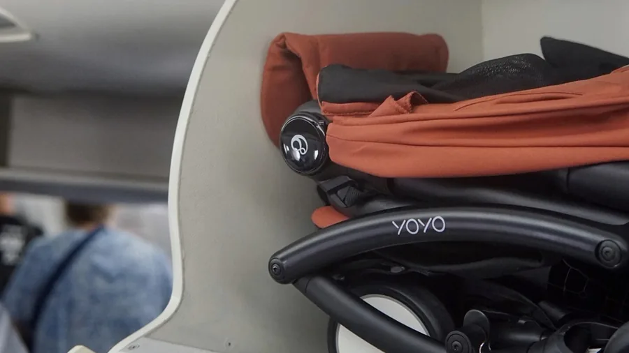Gefalteter Stokke YOYO⁵ im Handgepäckfach eines Flugzeugs