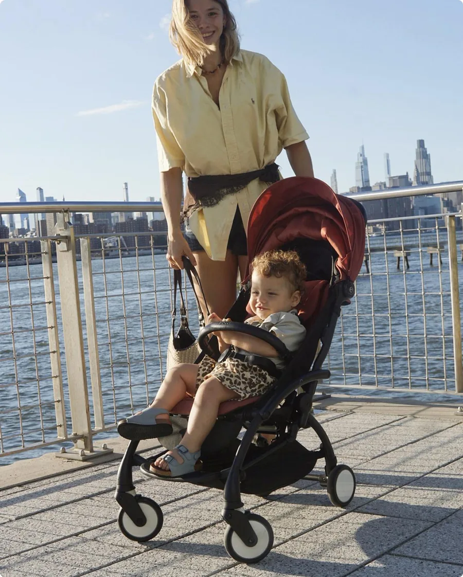 Kind im Stokke YOYO⁵ auf einer Uferpromenade